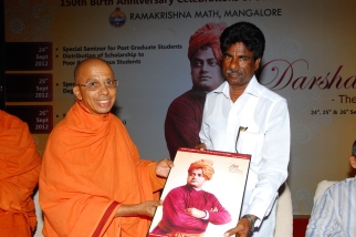 Swami Jitakamananda presenting our token of love to Sri Kota Srinivas Poojari